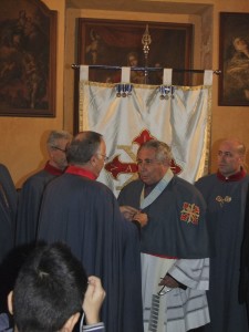 il vice-delegato del Lazio, Cav. Gr. Croce, avv. Franco Ciufo sistema il nastro da collo al neo commendatore di Grazia ecclesisatico, don Elio Persechino