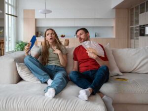 Persone sul divano accaldate con il ventaglio