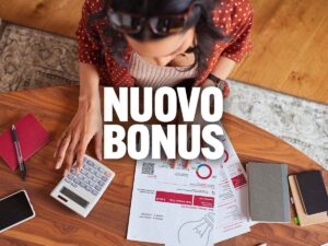 scritta nuovo bonus con dietro una ragazza con calcolatrice e fogli