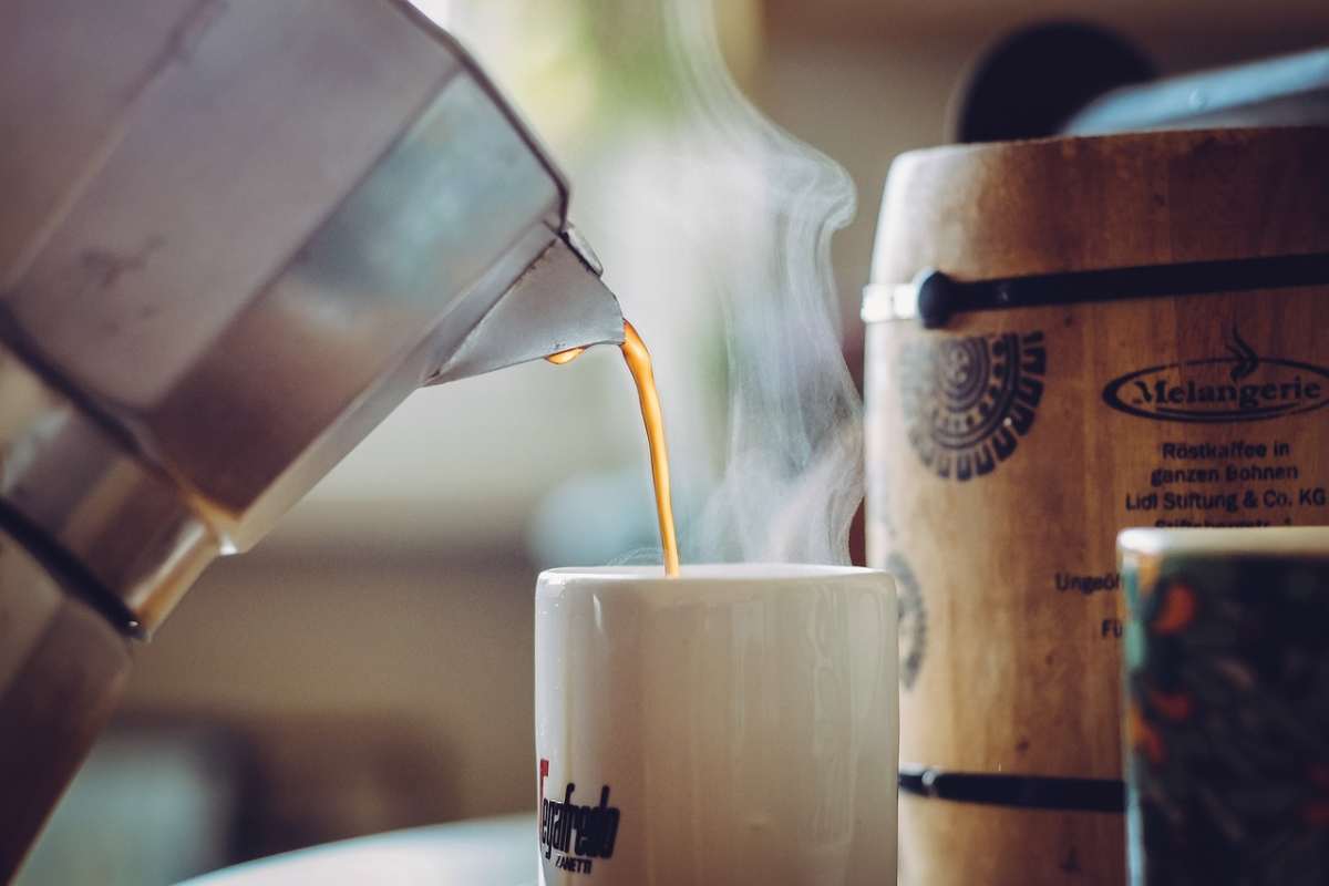 caffè versato in una tazzina da una moka
