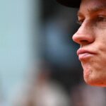 Primo piano di Jannik Sinner con espressione ambigua