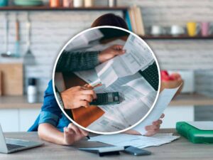 Uomo controlla le multe e fa i conti con una calcolatrice