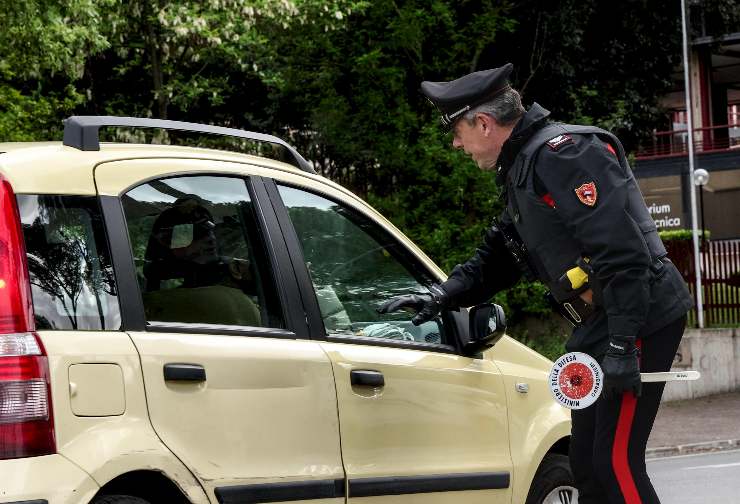 un carabinieri ferma un'auto a un posto di blocco