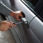 ladro tenta di aprire portiera di un'auto