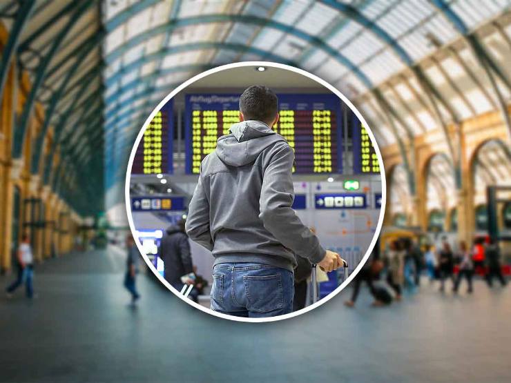 una persona guarda gli orari dei treni in stazione