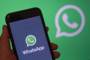 Schermata WhatsApp su un cellulare in mano
