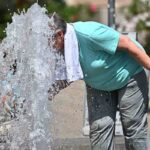 Anziani si rinfrescano presso una fontana