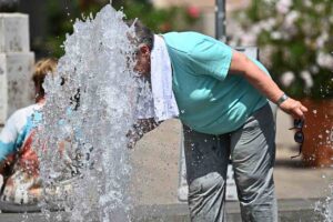 Anziani si rinfrescano presso una fontana