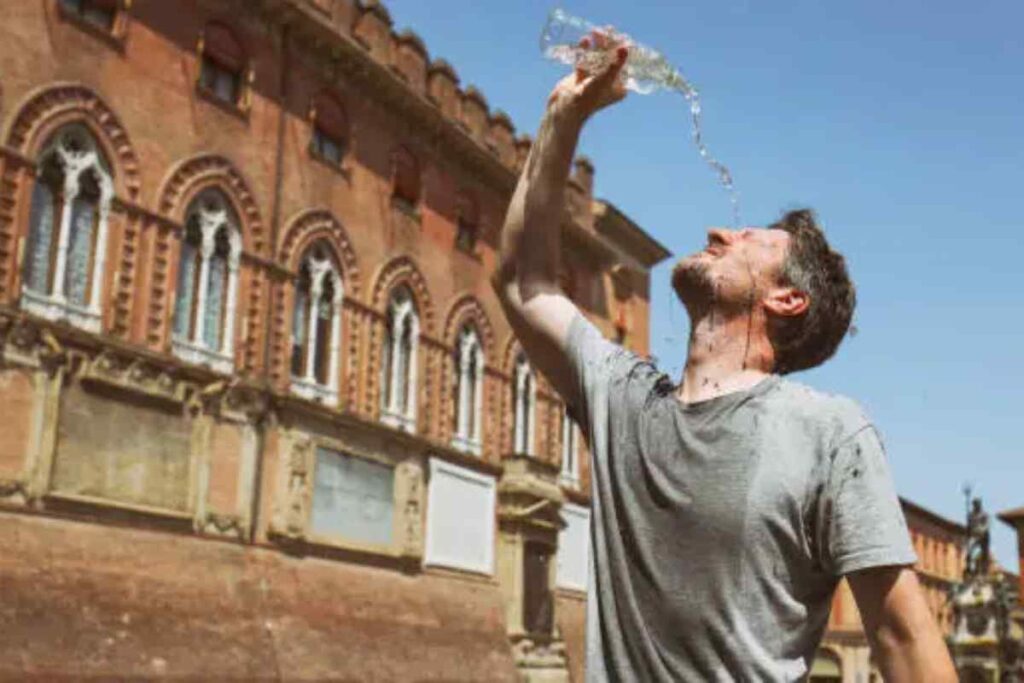persona che si getta acqua addosso per il caldo