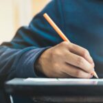 una persona scrive con la matita