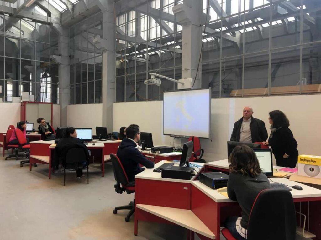 persone in una stanza con tavoli e computer
