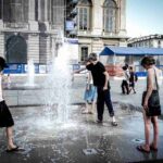 tre persone si rinfrescano con l'acqua di una fontana