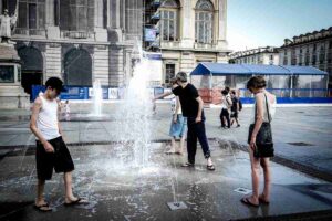 tre persone si rinfrescano con l'acqua di una fontana