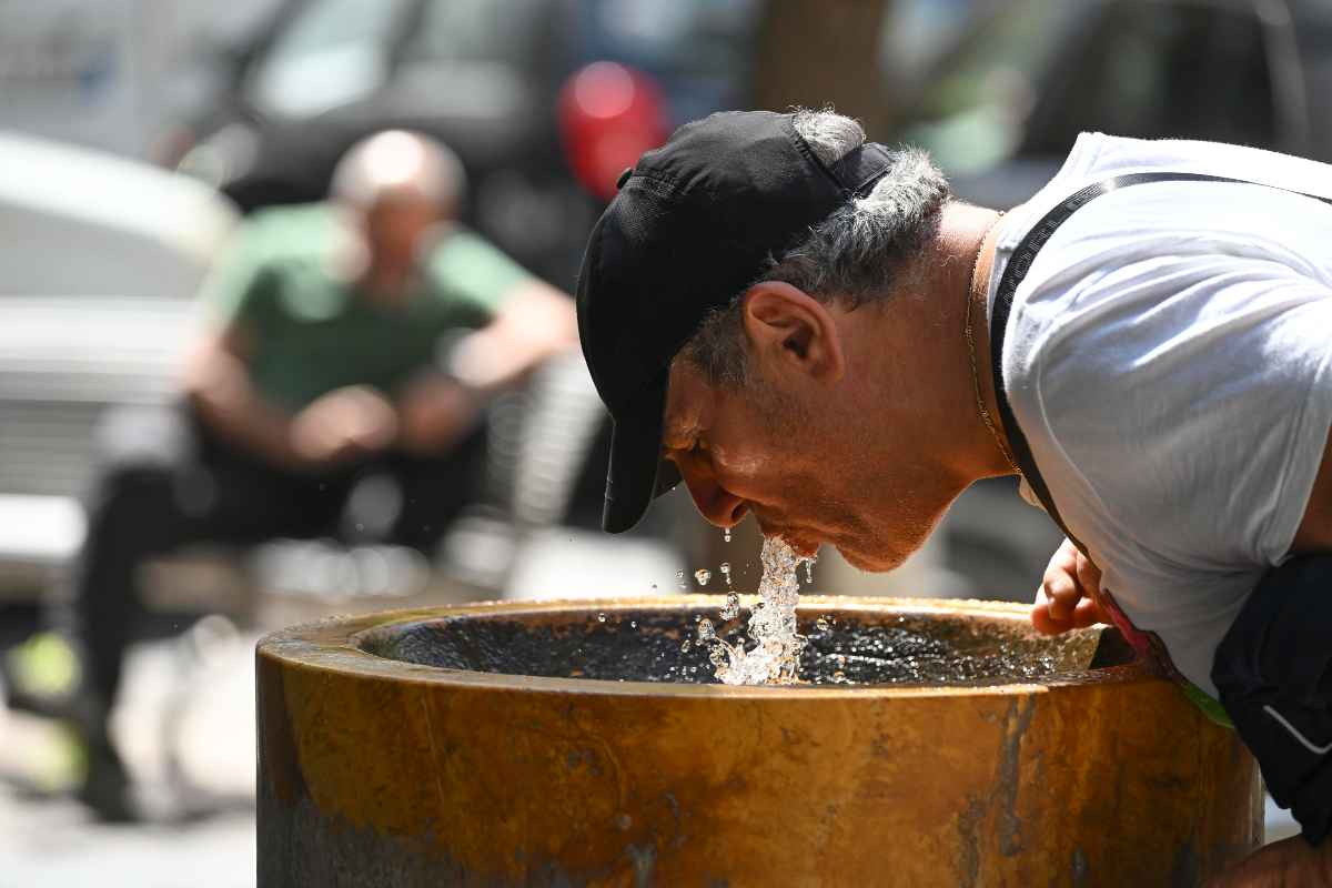 un uomo si disseta a una fontana