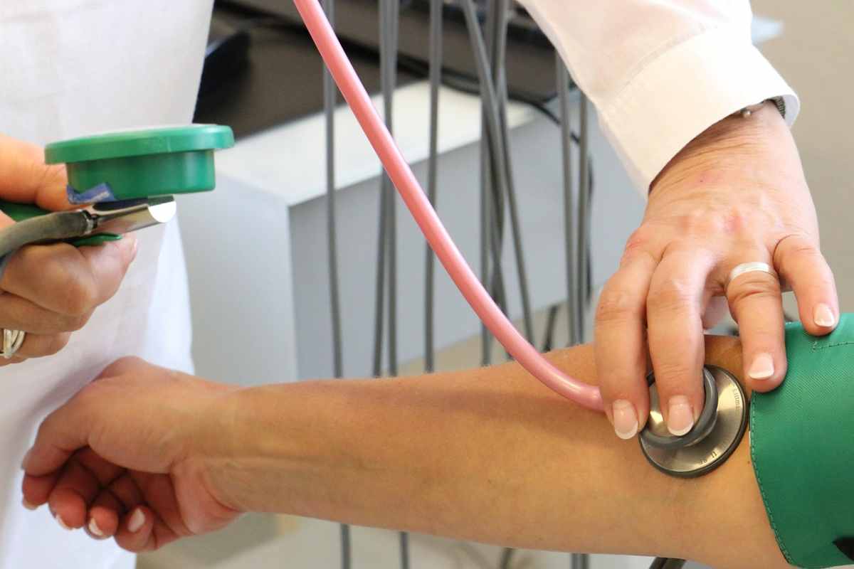 medico misura la pressione a un paziente