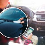 un uomo usa lo smartphone alla guida e una multa sul parabrezza