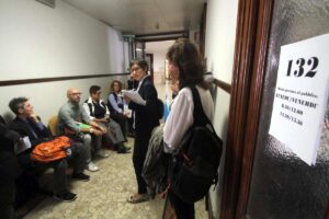 persone in attesa fuori un ufficio comunale