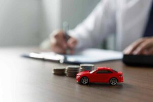 un'auto in miniatura con vicino delle monete