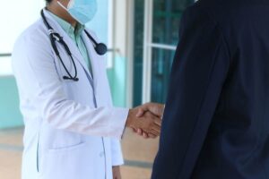 Medico che stringe la mano al paziente
