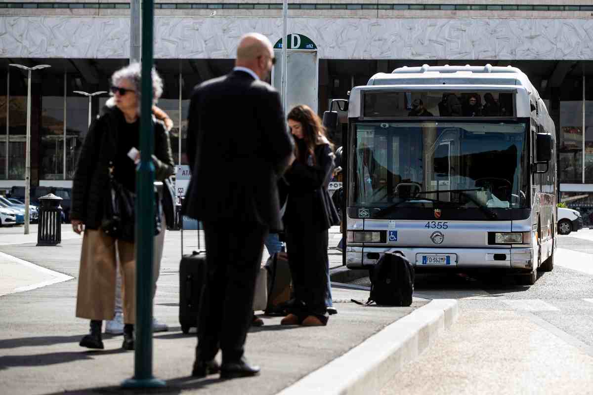 persone attendono autobus alla fermata