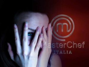 ragazzo con le mani sul volto e dietro il logo di Masterchef