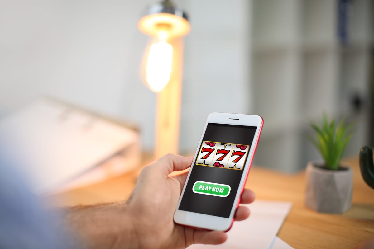 Primo piano di una mano maschile con in mano uno smartphone