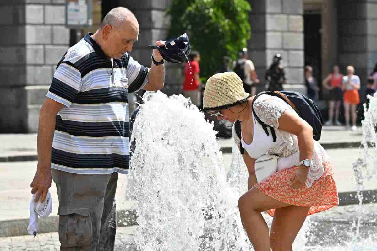 Persone si rinfrescano presso una fontana