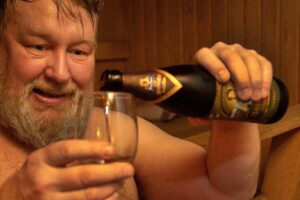 Un uomo versa della birra fredda in un bicchiere
