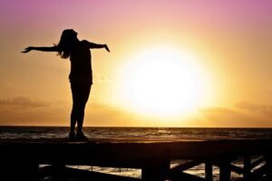 Donna a braccia spalancate davanti al sole