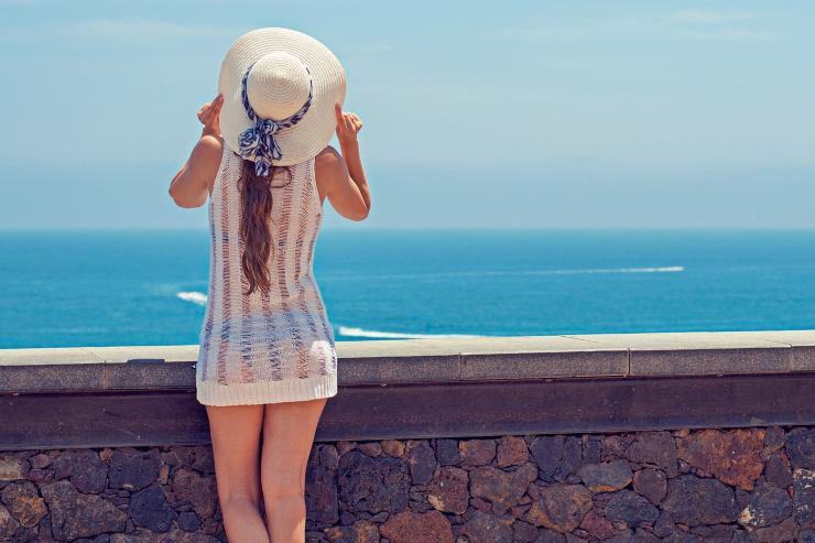 Donna con cappello davanti al mare