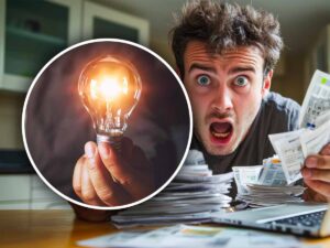 Lampadina accesa e persona davanti alle bollette