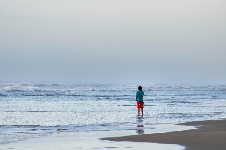 Persona in piedi in riva al mare