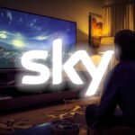 logo sky con dietro una persona che guarda la tv