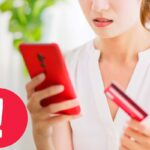 punto esclamativo segno di pericolo con dietro telefono e carta di credito