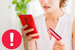 punto esclamativo segno di pericolo con dietro telefono e carta di credito