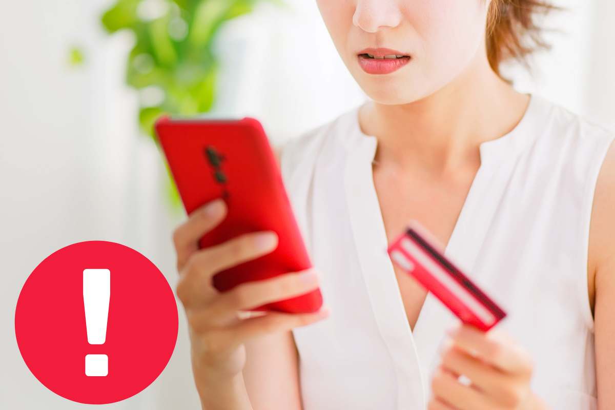 punto esclamativo segno di pericolo con dietro telefono e carta di credito