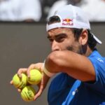 Matteo Berrettini con tre palline da tennis in mano