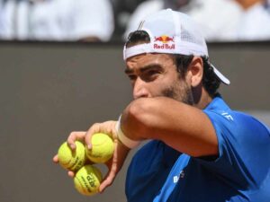Matteo Berrettini con tre palline da tennis in mano