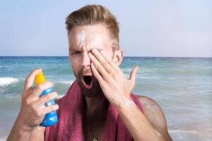un uomo si applica la crema solare sul viso