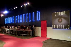 Esterno della casa del Grande Fratello con logo e porta rossa
