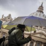 un uomo si ripara dalla pioggia con un ombrello