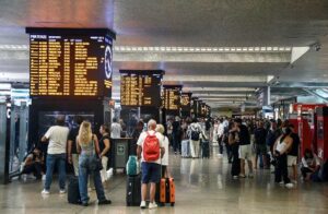 persone in stazione in attesa del treno