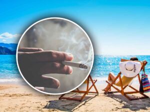 una sigaretta accesa con dietro due sdraio in spiaggia