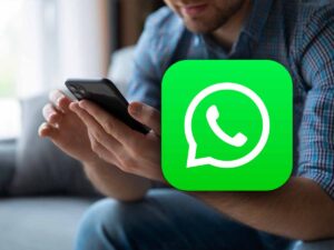 logo WhatsApp con vicino una persona che usa il telefono