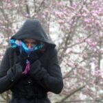Una donna si ripara dal freddo indossando un giubbino pesante