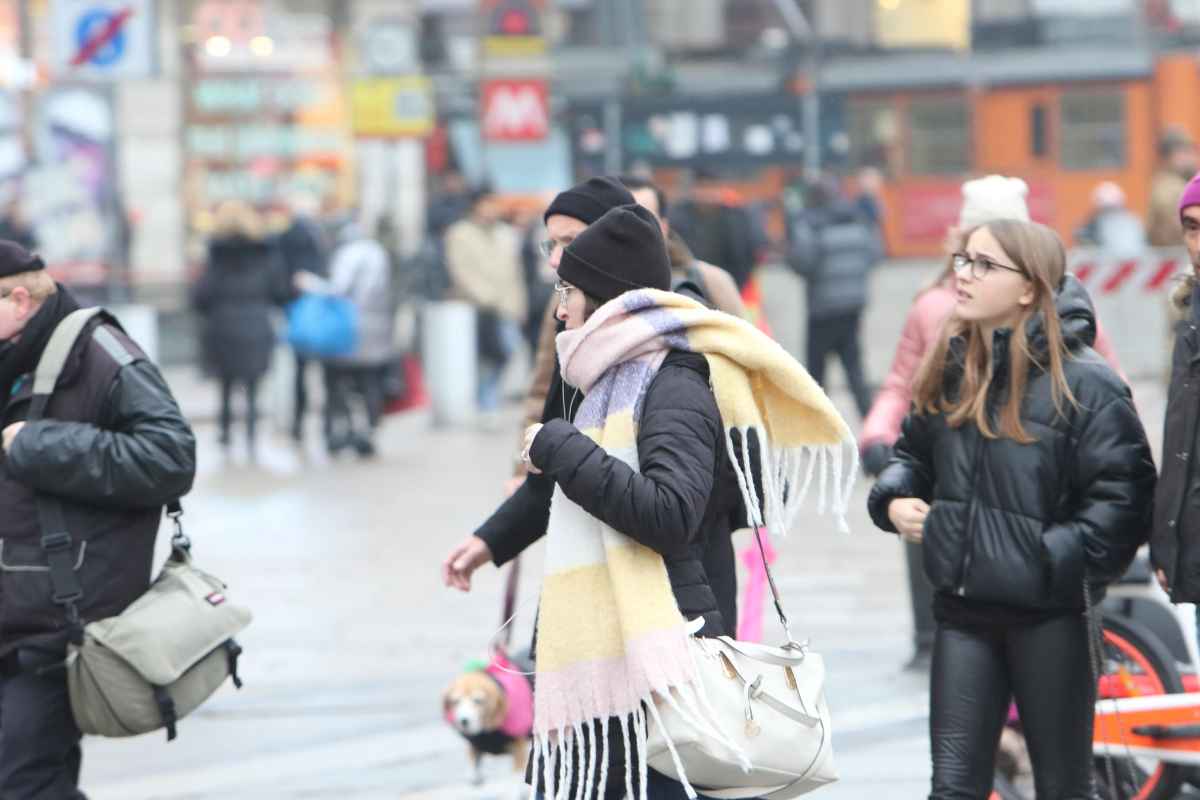 Persone camminano in strada indossando indumenti invernali