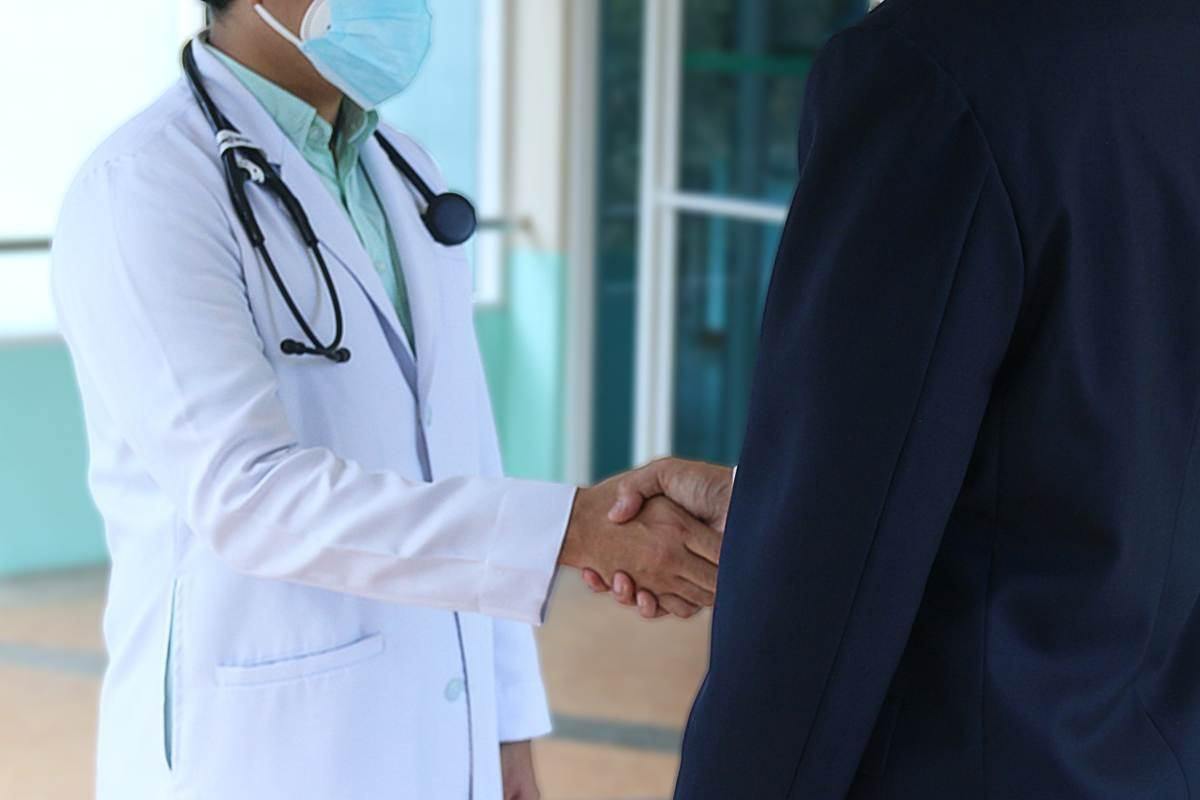 Medico che stringe la mano al paziente