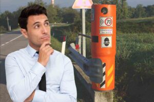 un uomo osserva un autovelox arancione