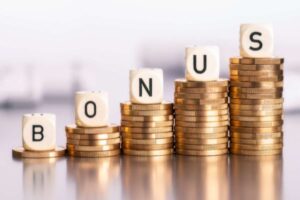 scritta bonus riprodotta su mucchi di soldi in moneta
