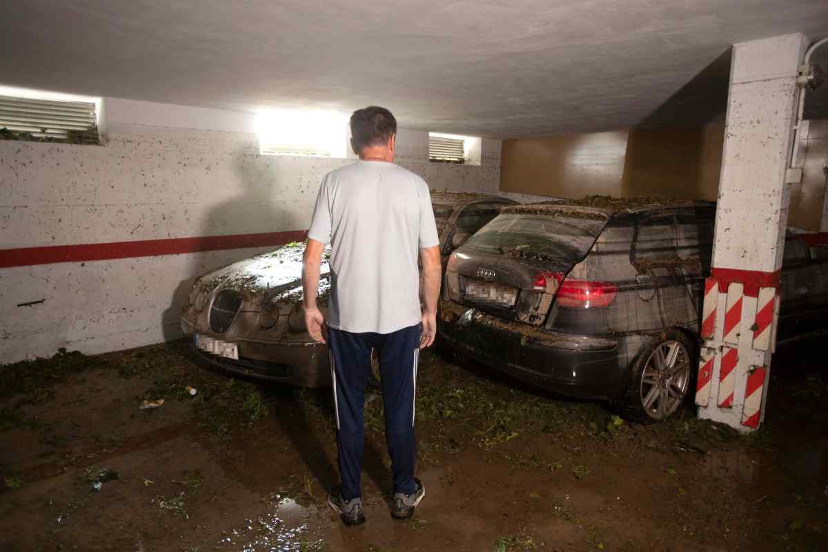 Persona in un garage con due auto
